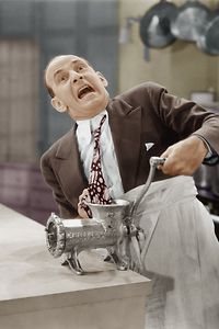 Man with tie stuck in meat grinder