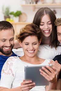 Picture of smiling friends around a tablet computer visiting an engaging Chef Corp. e-commerce experience