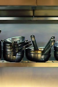 Picture of pots and pans in on a shelf in the kitchen